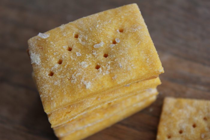 Photo shows a close up of sweet potato crackers on a table