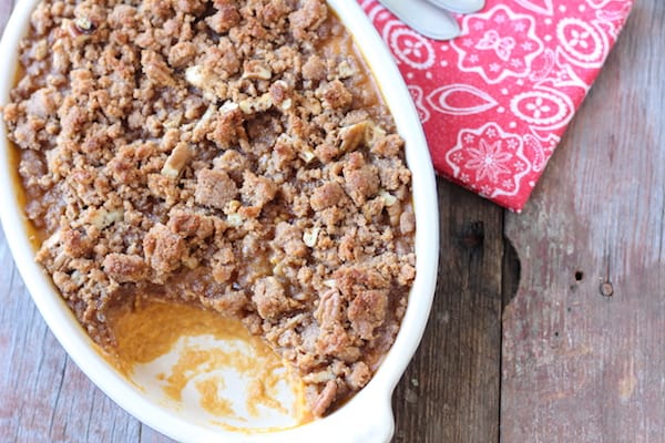 Image shows a dish of sweet potato casserole on a table 