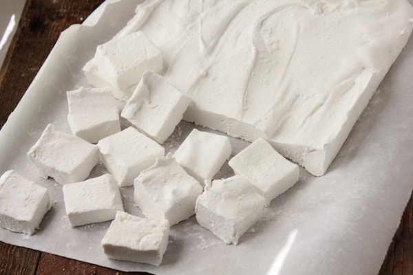 Image shows a pan of homemade marshmallows sliced into smaller pieces