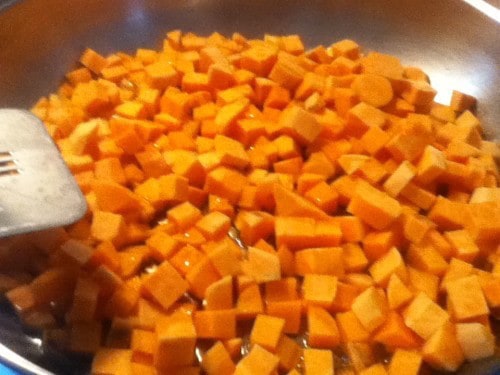 Image shows a pan full of diced sweet potatoes