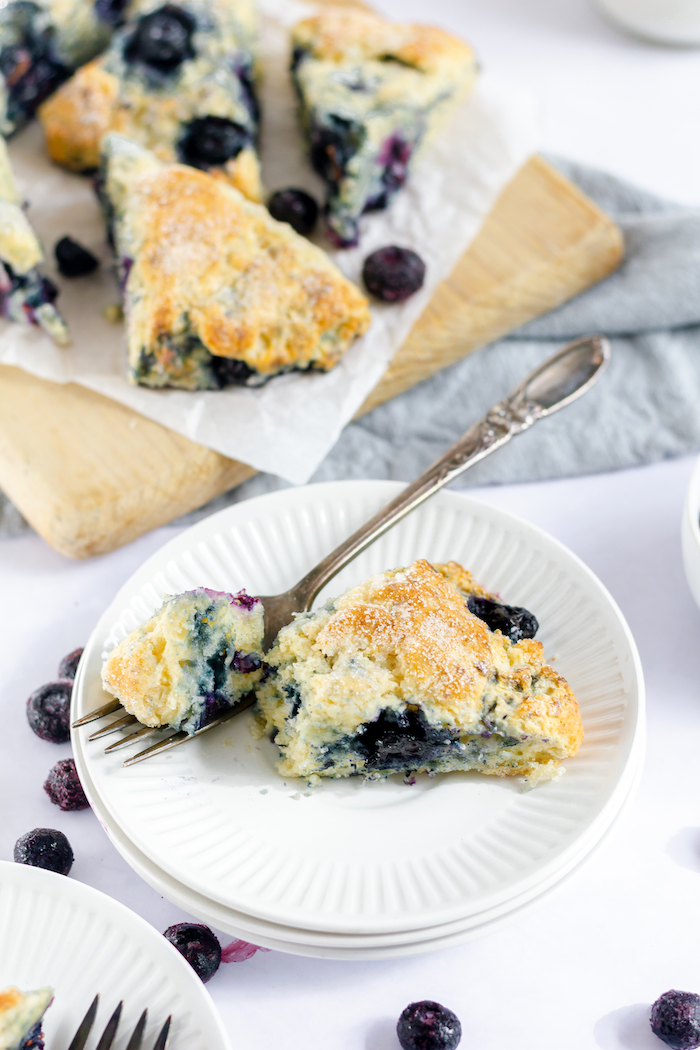 Image shows a plate of blueberry scones with a fork