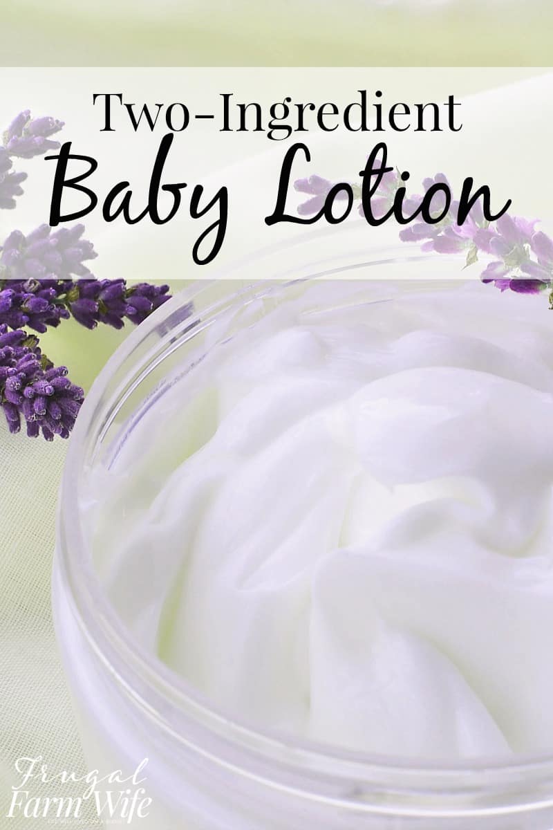 Image is an extreme close up of a jar of white, homemade baby lotion on a white cloth with some purple lavender behind it. Text overlay reads "Two-Ingredient Baby Lotion"
