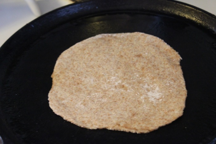Image shows a tortilla on a cast iron skillet