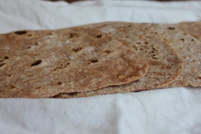Image shows several tortillas on a cloth towel