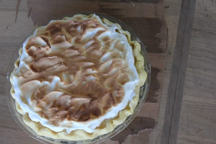 Image shows a lemon meringue pie on a table