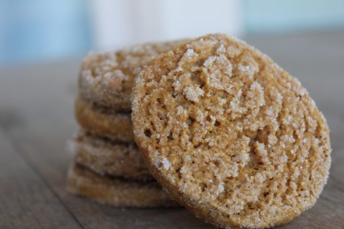 Image shows a pile of gluten free sweet potato cookies, with one leaning against the stack.