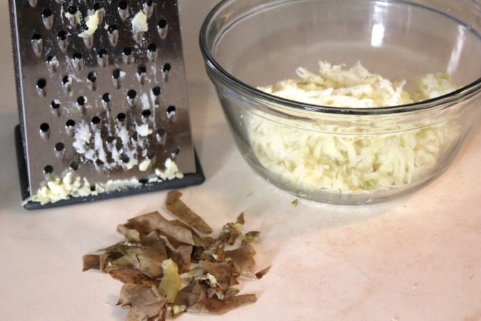 Image shows a grater, glass bowl and ingredients for gnocchi