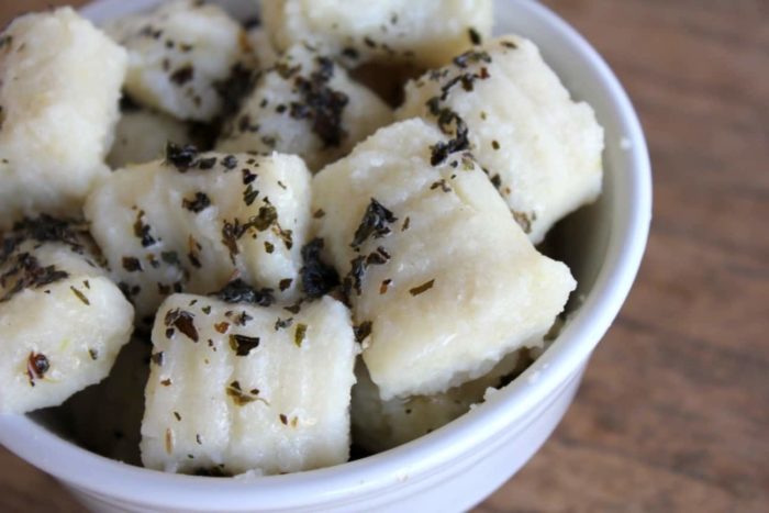 Image shows a bowl of gnocchi sprinkled with pepper flakes