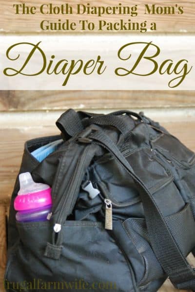 Image shows a diaper bag with text that reads "The Cloth Diapering Moms' Guide to Packing a Diaper Bag"