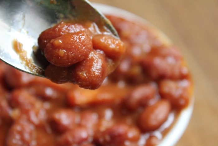Image shows a close up of vegetarian calico beans in a spoon