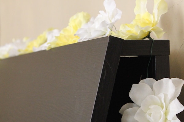 Photo shows a close up of a floral garland on a headboard