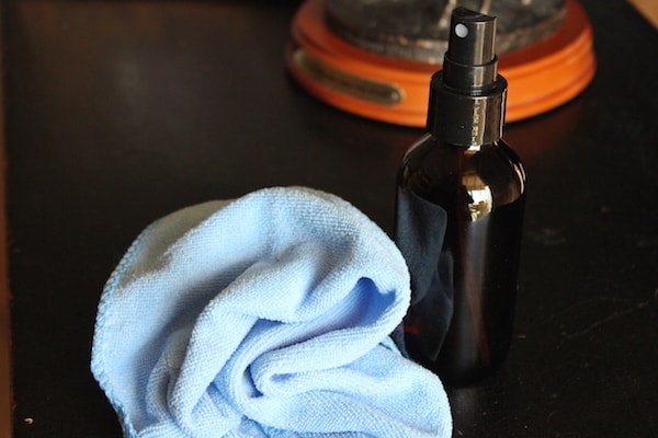 Image shows a cloth on a table next to a spray bottle 