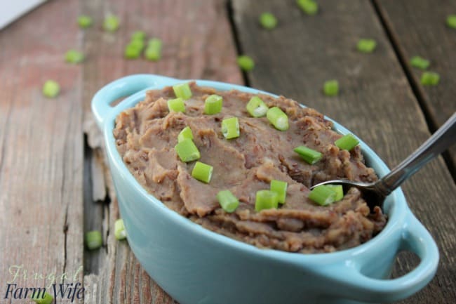 Photo shows a bowl of refried beans with a spoon