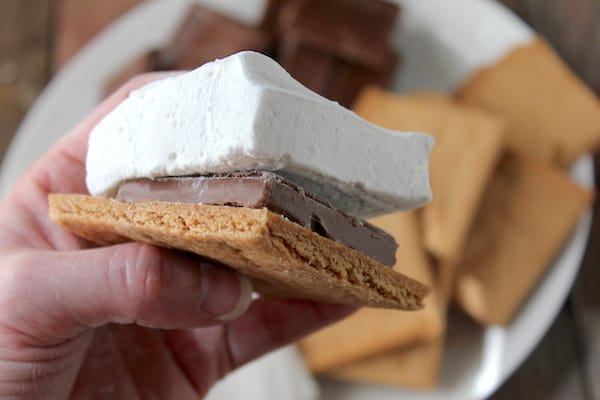 Image shows a smore made with homemade marshmallows and graham crackers