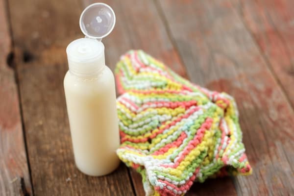 Image shows a bottle of homemade fash wash and a multicolor cloth