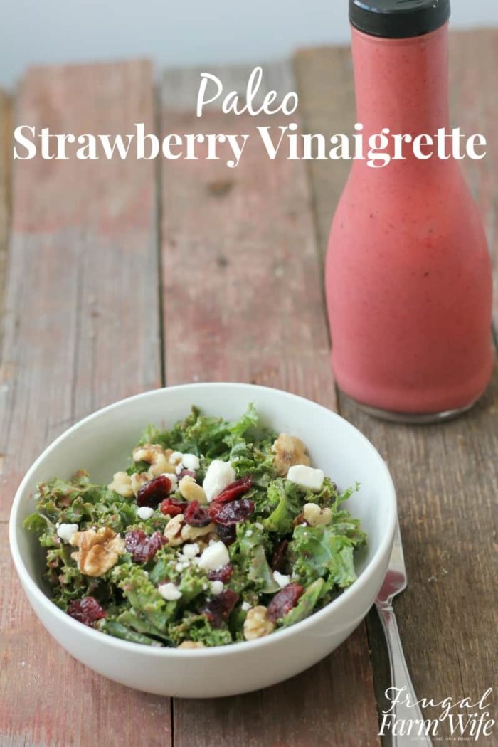 Image shows a bowl of salad topped with cranberries, next to a bottle of pink dressing with text that reads "Paleo Strawberry Vinaigrette"