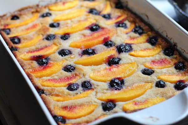 Image shows a pan of peach blueberry cobbler