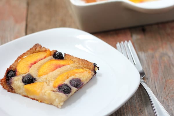 Photo shows a slice of peach blueberry cobbler on a plate