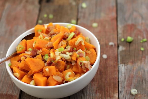 Image shows a bowl of sweet potato salad sitting on a table