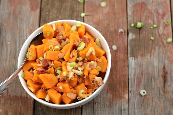 Photo shows a bowl of sweet potato salad on a table, photographed from above