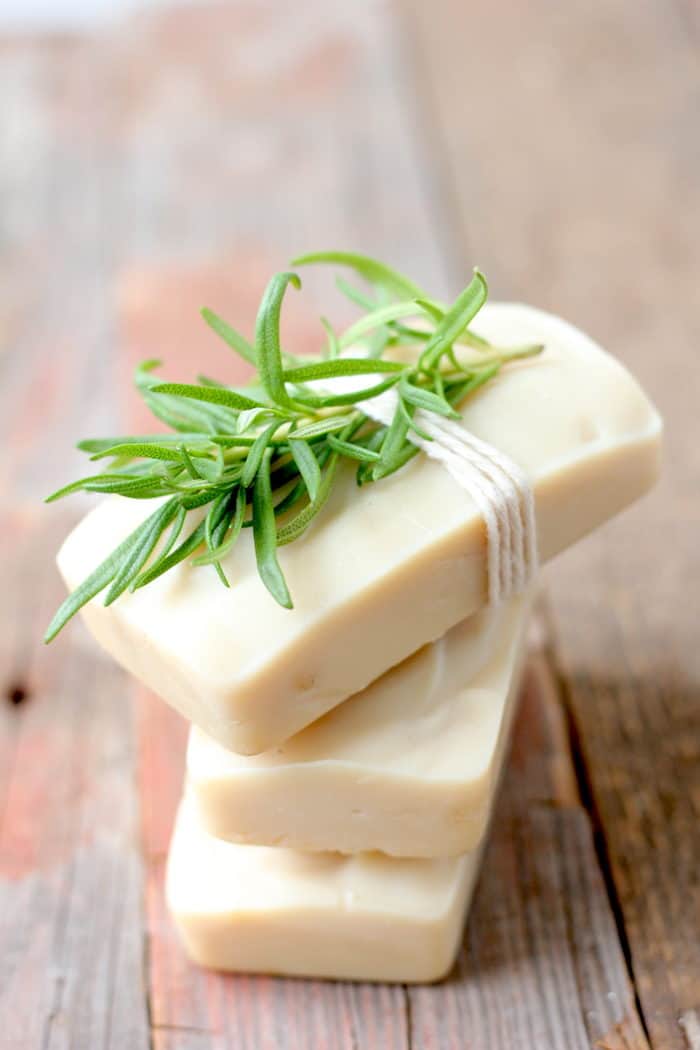 Photo shows a few bars of soap stakced and tied with rosemary on top