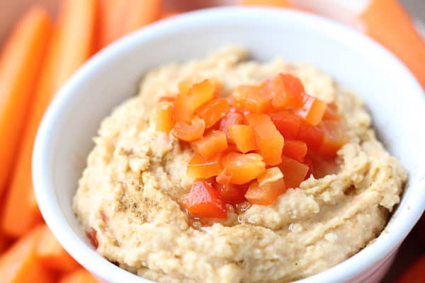 Image shows a bowl of roasted red pepper and garlic hummus
