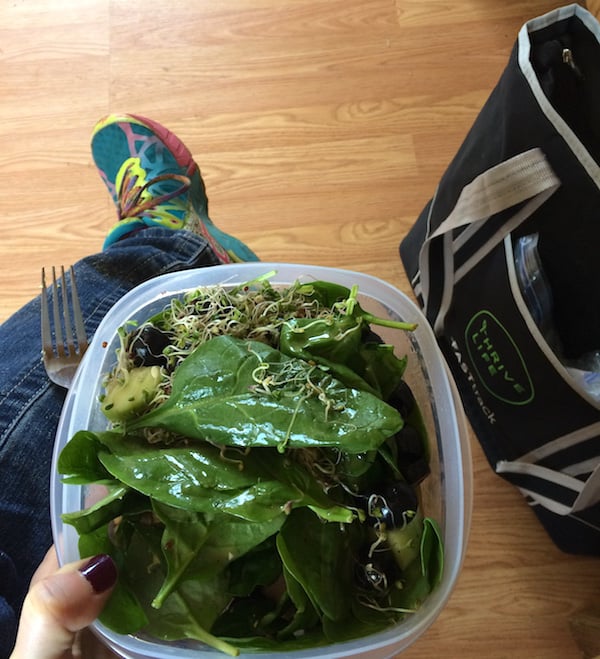 Image shows a person eating a salad in their lap