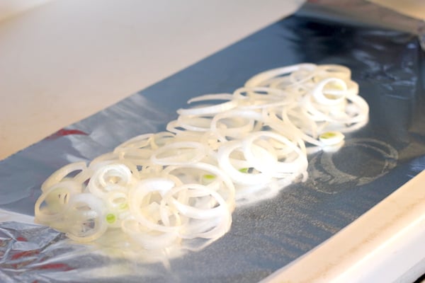 Image shows a piece of foil with onion slices