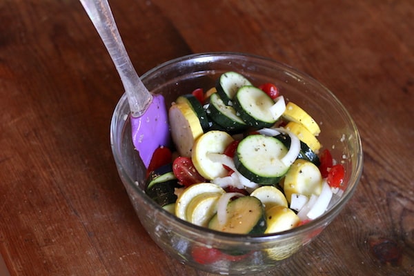 Photo shows a bowl of vegetables with a spatula and spices