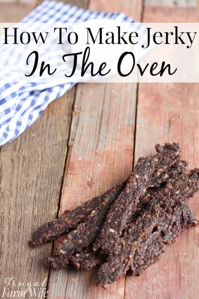 Image shows homemade jerky on a wooden table, with the text "How to Make Jerky in the Oven"