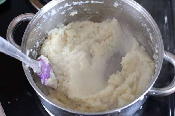 Photo shows a pot of cauliflower grits with a spatula in them