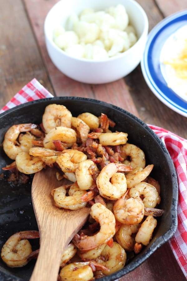Image shows a large pan of shrimp next to a bowl of grits