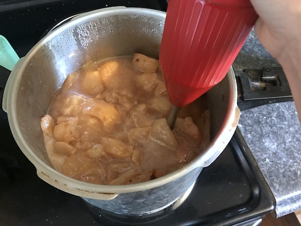 Image shows an immersion blender blending pears in a pot