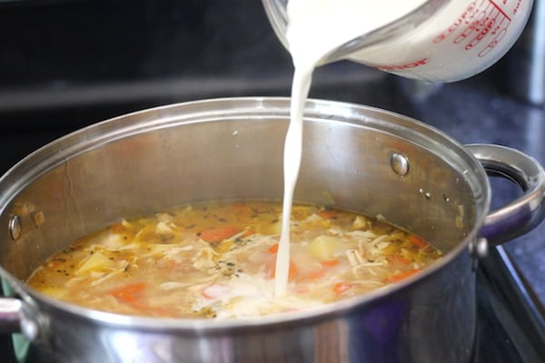 Image shows milk being added to the chicken soup