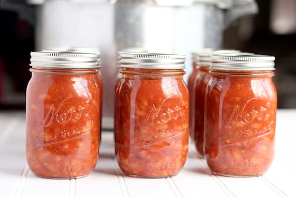 jars of canned chili beans outside a pressure canner