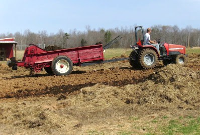 Image shows a tractor pulling a wagon over dirt