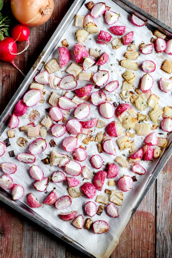 Photo shows a tray of radishes on parchment paper ready to be roasted