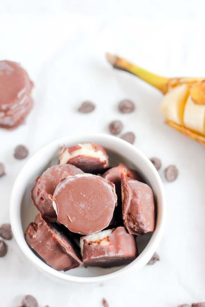 Photo shows a mug of chocolate-covered banana bites taken from above