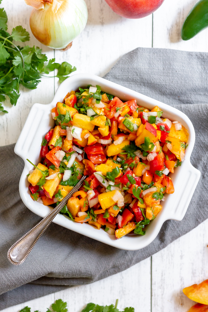 Image shows a dish of colorful peach and tomato salsa