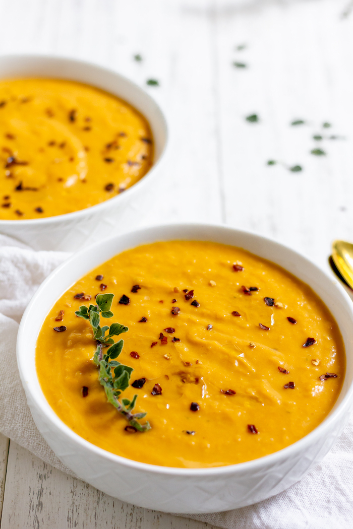 Photo shows two bowls of butternut squash soup on a table