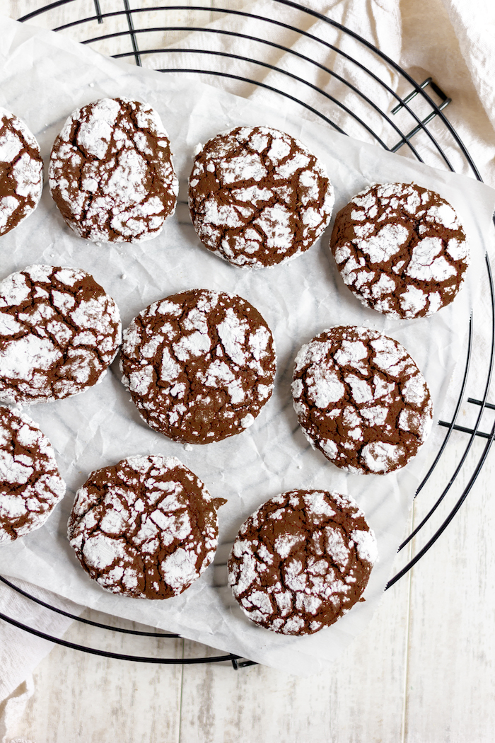 Image shows several chocolate crinkle cookies photographed from above