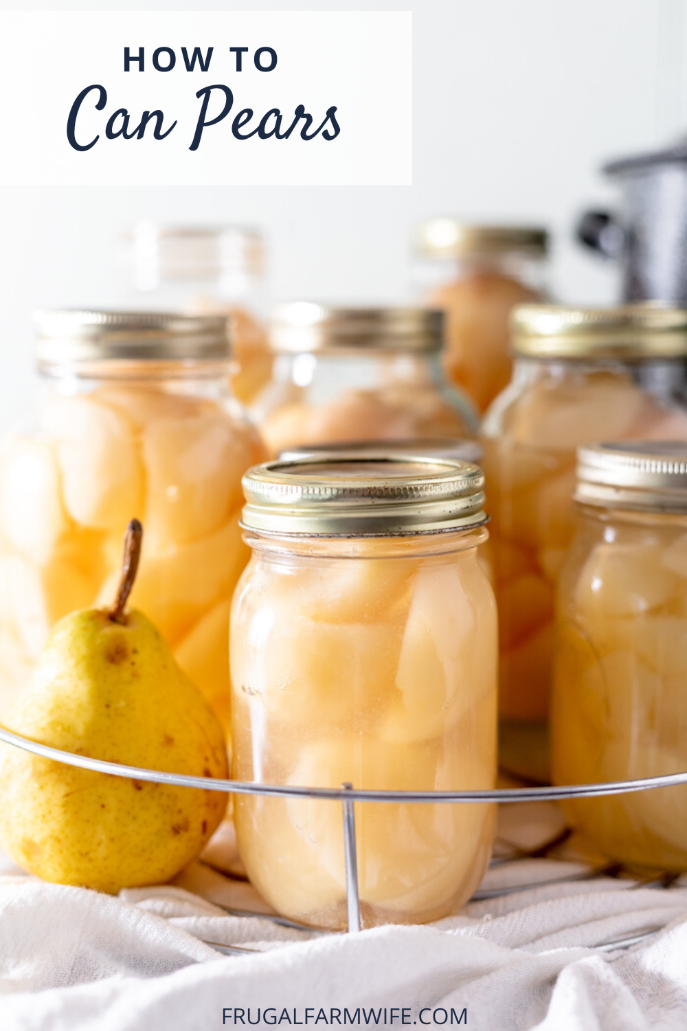 Image shows several mason jars full of sliced pears in juice on a wire rack. Next to the front jar sits a fresh pear. Above the image text reads "How to Can Pears"