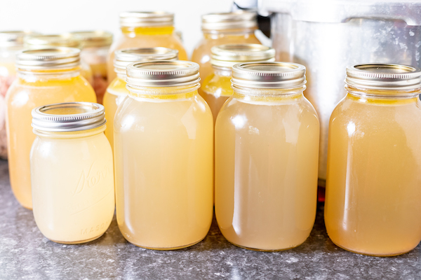 jars of chicken broth sitting on a cabinet