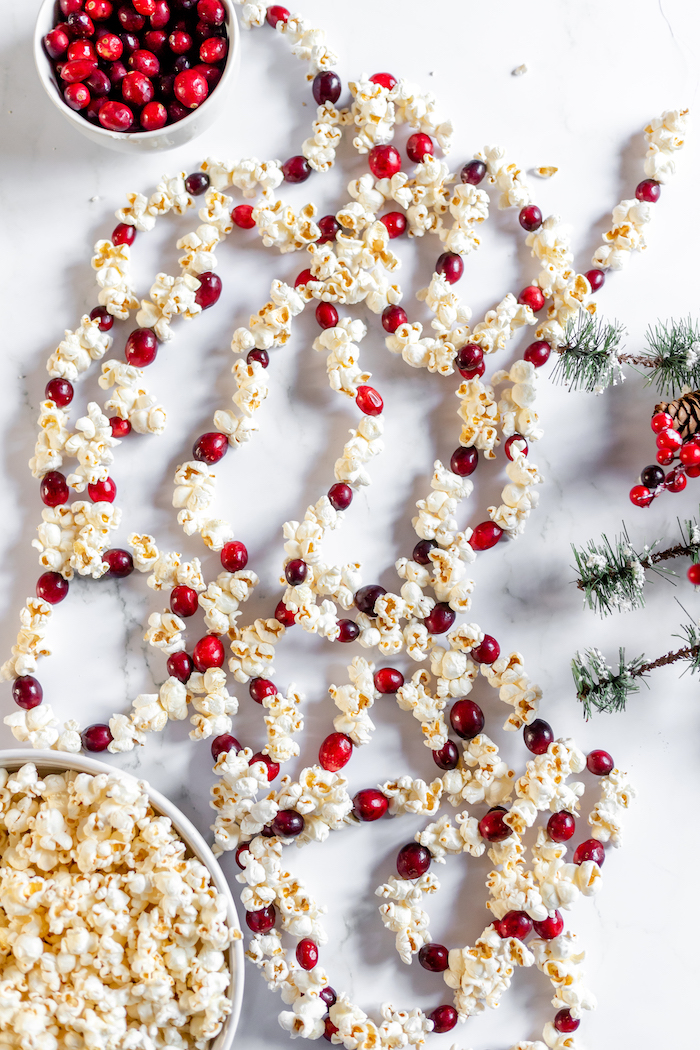 Image shows a string of popcorn garland to wrap around a Christmas tree laid out on a white table after assembly