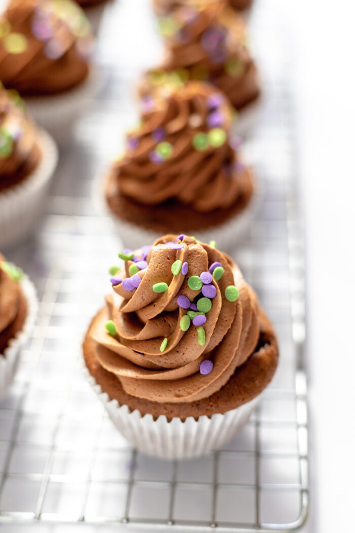 Chocolate buttercream icing with sprinkles on cupcakes