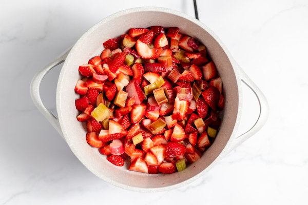 mixing strawberries and rhubarb in a pot