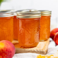 jars of peach jam on a white surface