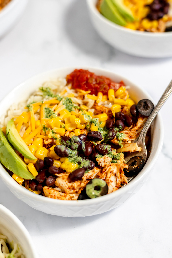 bowl of chicken, rice, and mexican toppings