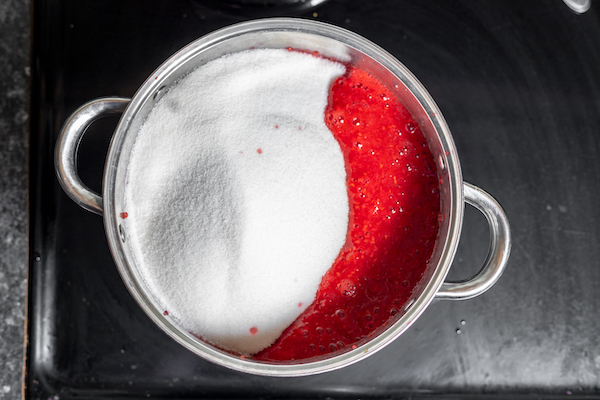 sugar added to crushed raspberries and fruit pectin to make jam. 